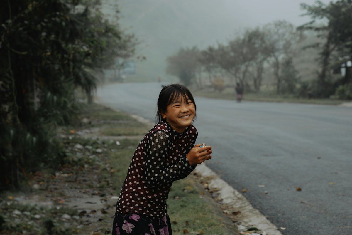 Em nhỏ đứng bên đường núi